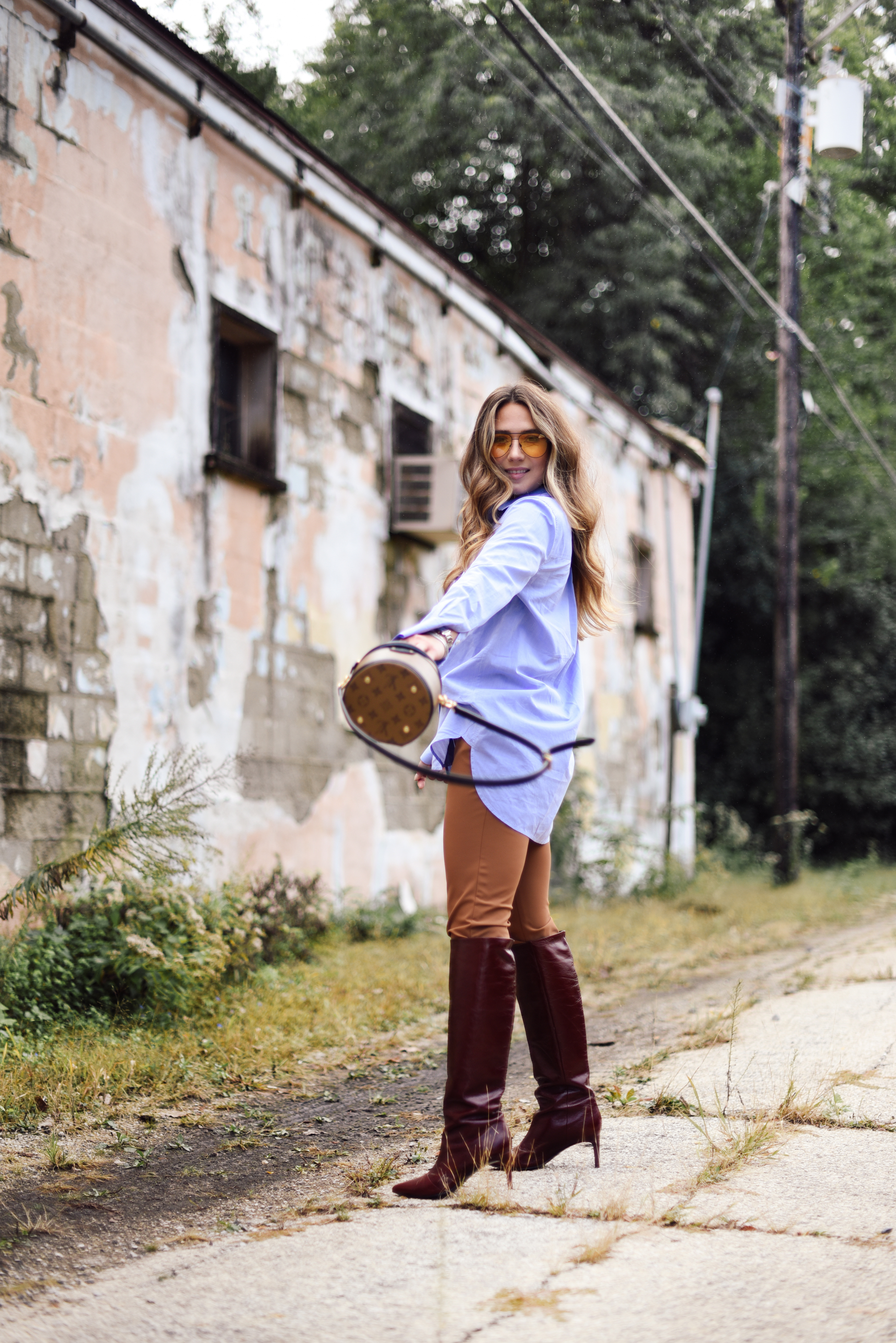 white-leather-jacket-button-up-shirt-blue-knee-high-maroon-boot-bucket-bag-fall-outfit-inspo-street-style-look