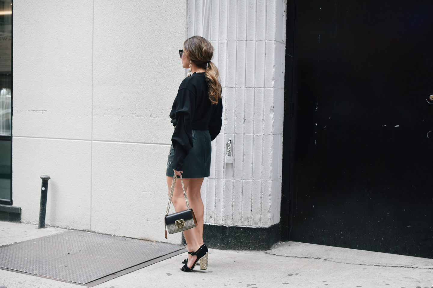 black-sweater-statment-leather-mini-skirt-dolce-and-gabanna-studded-block-heels-oversized-bubble-earring-nyfw-streetstyle