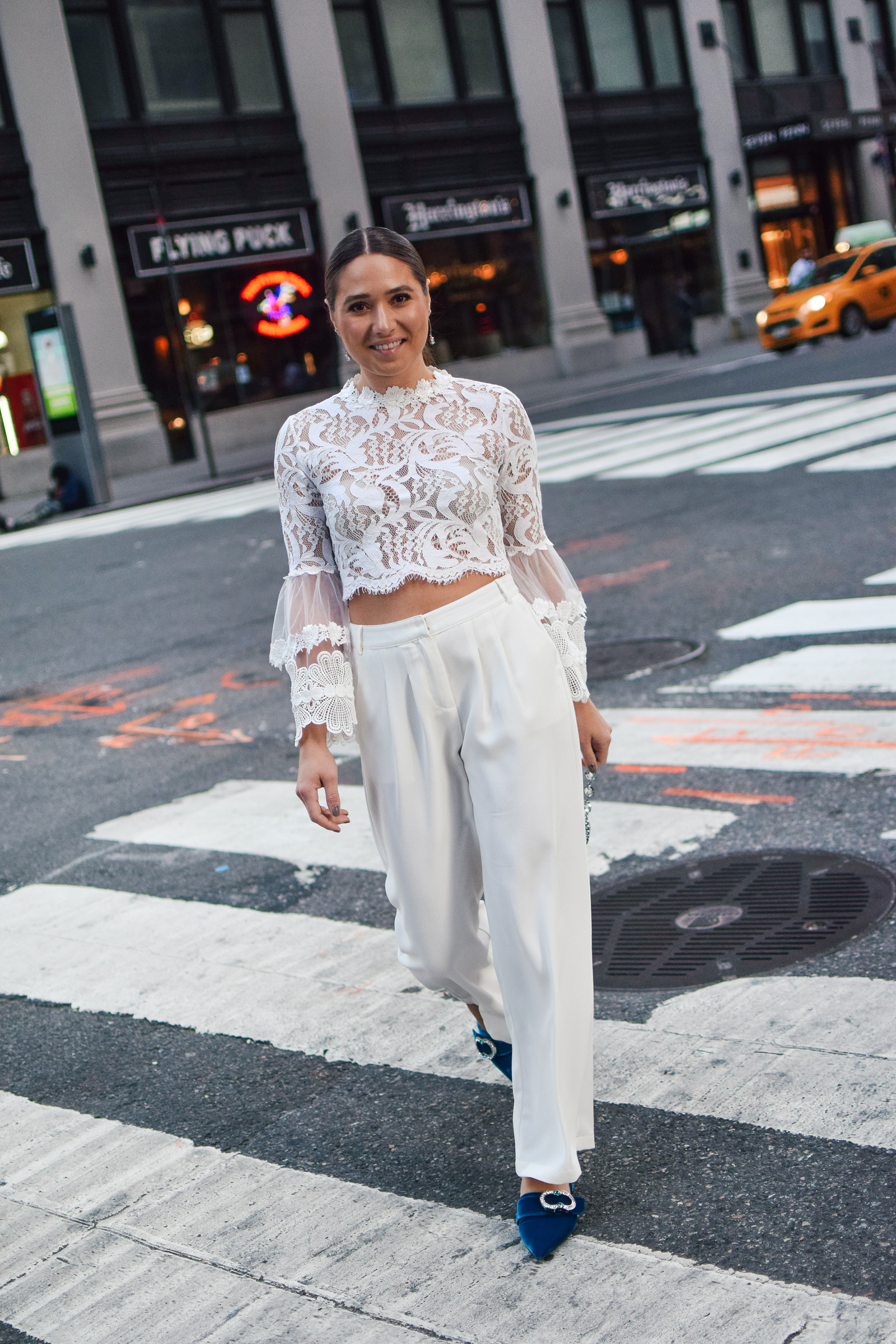 nyfw-streetstyle-outfit-lace-ruffle-statement-bell-sleeve-blouse-white-trousers-all-white-prada-royal-blue-slides-blush-accessories